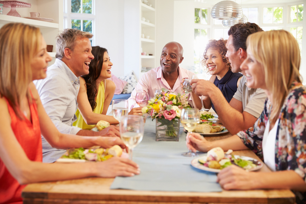 Mature Friends Sitting around Table at Dinner Party